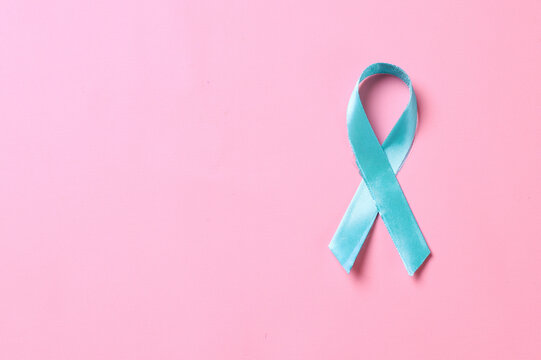 Teal awareness ribbon over pink background. Support to fight cervix cancer. 