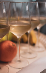 glasses of white wine on table next to fruit