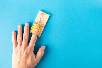Man's hand in a mousetrap. The concept of corruption, bribery, punishment for financial fraud.
