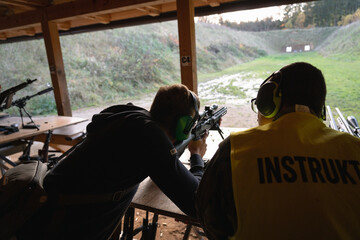 Training shooting weapons at an outdoor shooting range.