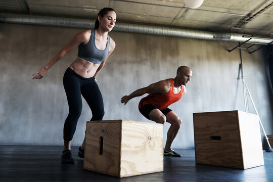 Gym, couple and exercise with box jump for training, workout and intense cardio on wall background. Health, fitness and people at a sports center for wellness, performance and endurance challenge