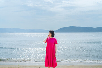 Fototapeta na wymiar 晴天の海を散策する女性