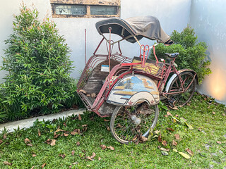 Fototapeta na wymiar Beautiful Indonesian Traditional Pedicab or called Becak Kayuh. This is a good tourism transportation in Yogyakarta City, Indonesia. Concept for vintage classic retro vehicle, and vacation.