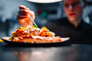 chef decorated plate with food on kitchen