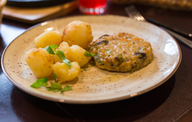 squash burger with boiled potatoes on a plate