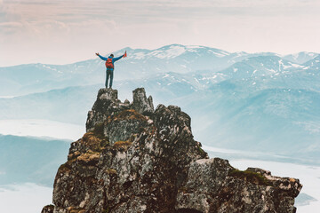 Man climbing mountain in Norway adventure travel outdoor extreme active lifestyle vacations tour hiking climber success raised hands on the top of Husfjellet peak with norwegian flag - obrazy, fototapety, plakaty