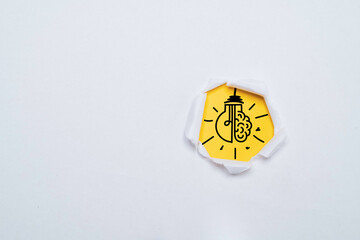 Drawing of lightbulb with brain inside yellow punch paper for creative thinking idea and problem...