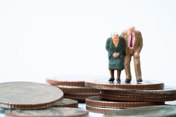 Couple Senior Pensioners miniature figure standing on the top coins stacking for wealth financial...