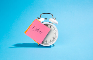 White alarm clock and sticker with the inscription Late on a blue background.