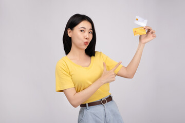 Young casual female paying with credit card, smiling happy fun on white background studio portrait.