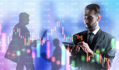 Focused investor. Man trader is following charts. Businessman with tablet computer. Investing in...