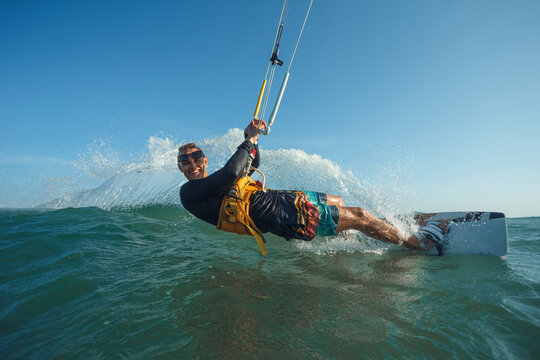 Kite surfer riding a kiteboard on the sea with splash