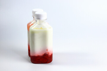 Bottles of home made fruit drinking yogurt, selective focus on white background