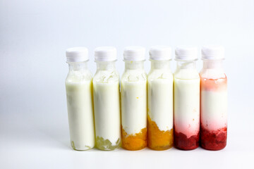 Bottles of home made fruit drinking yogurt, selective focus on white background