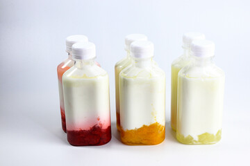 Bottles of home made fruit drinking yogurt, selective focus on white background
