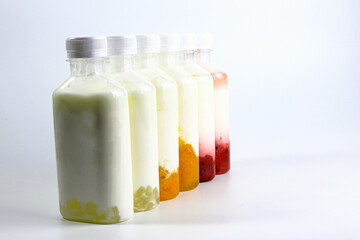 Bottles of home made fruit drinking yogurt, selective focus on white background