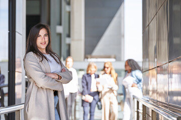 Profesional businesswoman looking at camera while posing outside the office building. Business concept.