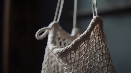 Obraz premium A close-up of an empty cotton string bag hanging on a hook. Generative AI