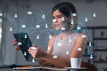 Smiling businesswoman in casual wear holding tablet device touching it at office workplace. Concept of distant work, business education, information technology. Social network abstract hologram