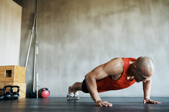 Workout, muscular and man doing gym studio push up for exercise, health performance and sports training for muscle building. Bodybuilding routine, determination or strong person doing floor pushup