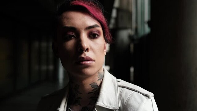 Pensive androgynous non-binary person in alley.