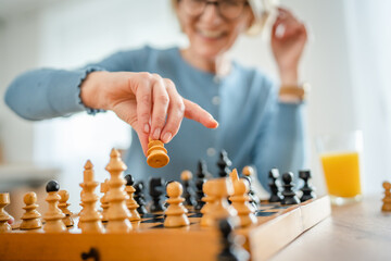 two women mature senior females sisters play chess board game at home