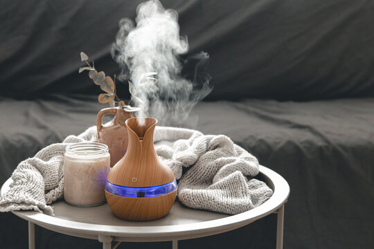 Spa composition with aroma oil diffuser lamp and candle on a blurred background.