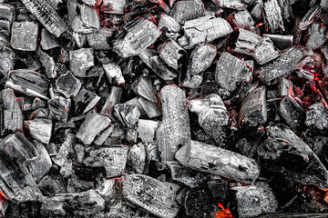 The texture of burning firewood and charcoal with the remnants of the heat. Ash after the fire. Light back.