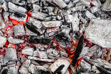 The texture of burning firewood and charcoal with the remnants of the heat. Ash after the fire. Light back.
