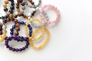 Collection of crystal gemstones bracelets on the table.  - obrazy, fototapety, plakaty