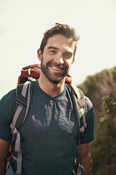Hiking, smile and portrait of man on mountain for fitness, adventure and travel journey. Backpack, summer and workout with face of male hiker trekking in nature path for training, freedom and explore