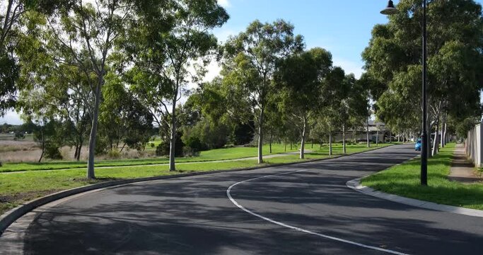 A tree-lined suburban road in a quiet residential neighbourhood of Melbourne. Beautiful and clean living environment in a suburb. Truganina VIC Australia.