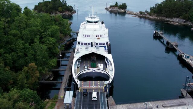 Loading of cars into vehicle ferry in Norwegian port. Transportation of vehicles and passengers on busy tourist route between islands through fjords