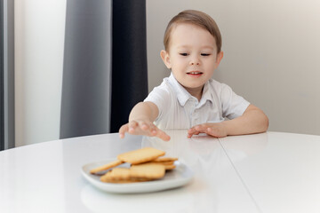 cute little boy looking at sweets with joy, sweet tooth, sugar addiction