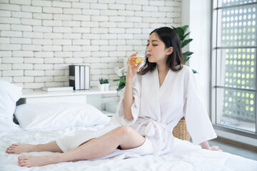 Obraz na płótnie Canvas Japanese female drink wine on the bed