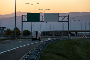 Fototapeta na wymiar White delivery van on the highway. White modern delivery small shipment cargo courier van moving fast on motorway road to city urban suburb. The business distribution and logistics express service.