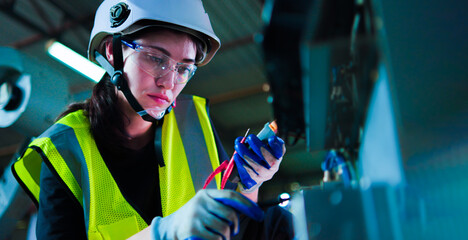 Female electrical engineer working control check meter voltage and current in enclosure.