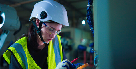 Female electrical engineer working control check meter voltage and current in enclosure.