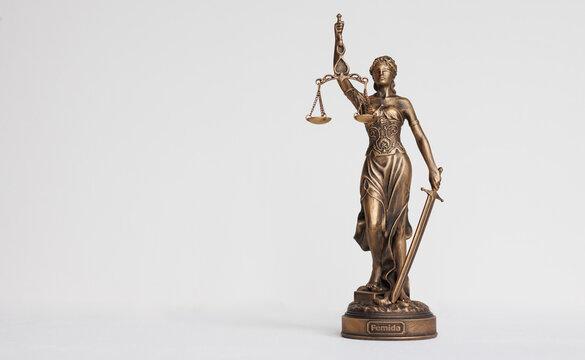 themis goddess of justice statuette on light background. symbol of the law with scales and sword in his hands. legal company or university of law and judicial structure. bar association and human