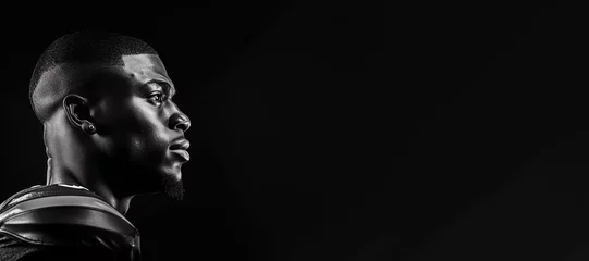 Fotobehang Black and white photorealistic studio portrait of an American football player on black background. Generative AI illustration © JoelMasson