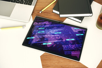 Top view of modern digital tablet monitor with abstract programming language hologram and world map, artificial intelligence and neural networks concept. 3D Rendering