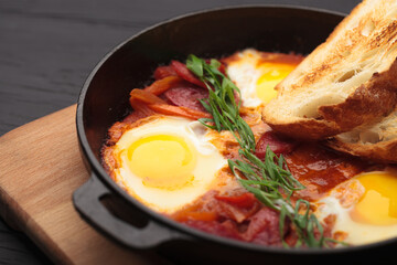 Fried eggs with beautiful yolks and sausages in a cast-iron skillet