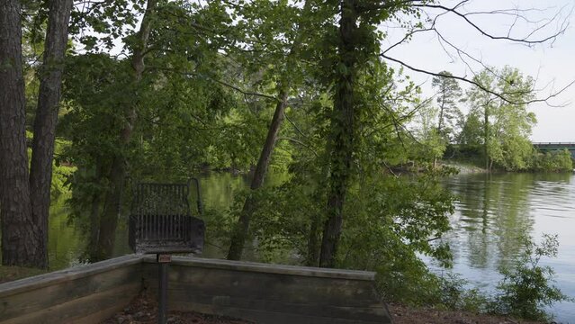 footage of a gorgeous spring landscape at Proctor Landing Park at sunset with rippling water surrounded by lush green trees and plants at Lake Acworth in Acworth Georgia USA