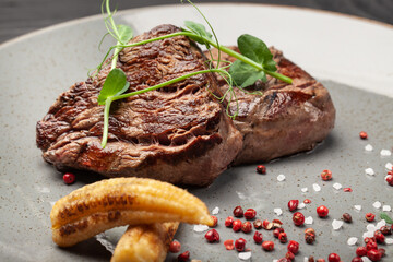 Fried juicy meat beef on a plate with sauce and spices