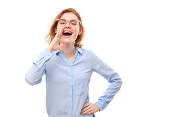 Portrait of redhead young woman screaming into her palms on white studio background. Important information, news concept