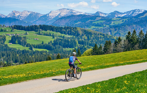 senior woman mountain biking on a electric mountainbike in early spring, in the Allgaeu Area, beolow Hochgrat summit near Oberstaufen,bavarian alps,Germany