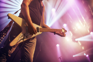 Guitar, man and performance for concert, rock or singing at party, event or celebration in night. Male musician, artist or rockstar with instrument at music festival for art, sound or talent on stage
