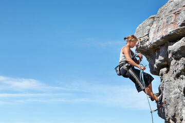 Rock climbing, blue sky and freedom with woman on mountain cliff for adventure or travel with space. Strong, challenge and mockup with female climber training in nature for courage, safety or workout