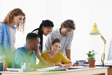 Diversity, happy business people and writing in meeting for collaboration, planning or strategy at the office. Group of diverse employees working on paperwork, documents or brainstorming at workplace