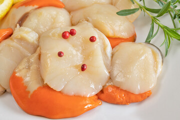 plusieurs Saint-Jacques crues dans une assiette	